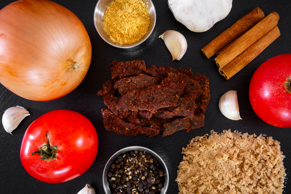 bbq bandit premium beef jerky surrounded by ingredients on a dark slate background