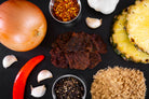 joe cocky teriyaki premium beef jerky surrounded by ingredients on a dark slate background