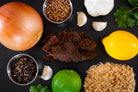 lime garlic mojo premium beef jerky surrounded by ingredients on a dark slate background